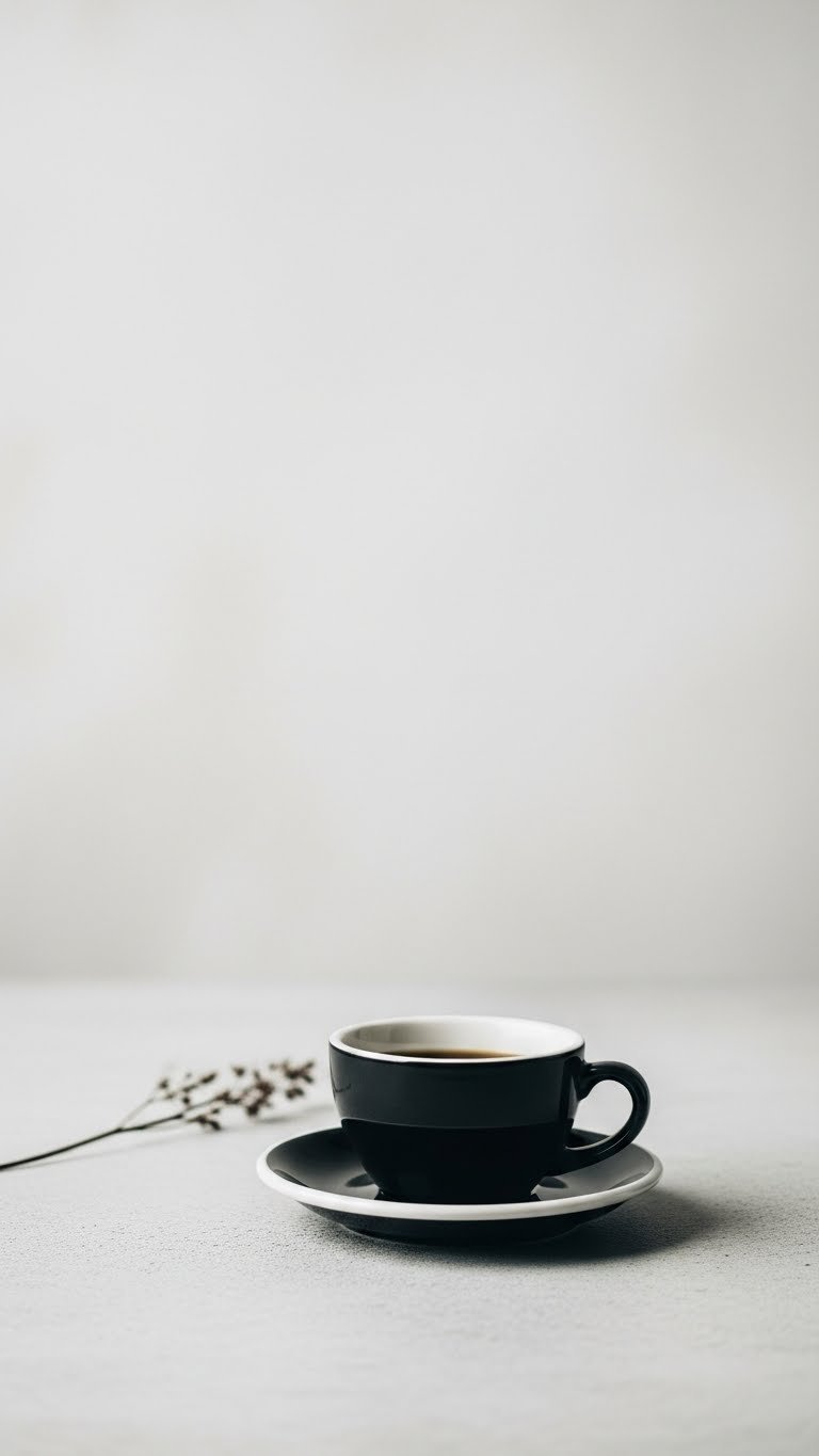 Master Black Coffee Aesthetic: 7 Minimal Design Secrets 3 Black coffee cup positioned off-center on light gray concrete surface with negative space and minimalist botanical stem