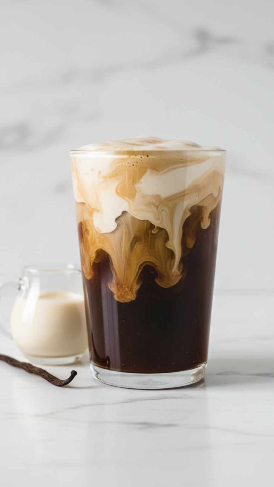 Finished Starbucks-style vanilla sweet cream nitro cold brew in clear cup showing marbling layers with dark coffee and creamy topping